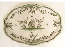 Oval earthenware dish from Moustiers with a figure, flowers, and foliage, 18th century